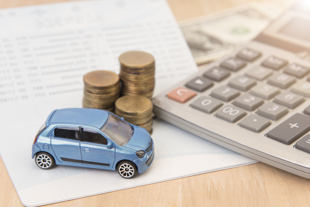 Illustration photo of toy car sitting next to coins and calculator